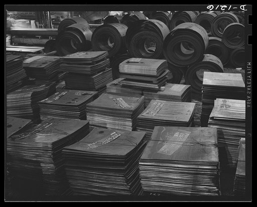 Steel manufacture, Allegheny-Ludlum. This is semi-finished material for finishing in steel mills and strip mills. The piles of rectangular pieces in the foreground are for steel mill production, while the coils behind them are destined for the strip mill where they will be converted into thin gauge 