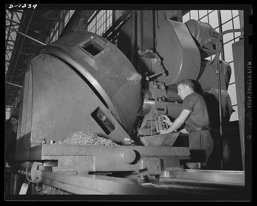 Chrysler tank arsenal. This is a milling operation. The four-pound metal piece with the aperture is actually the turret for a 37 mm anti-aircraft gun, part of the equipment for an M-3 tank. Extreme accuracy is required in the milling of these parts, because it is important that they be able to move 