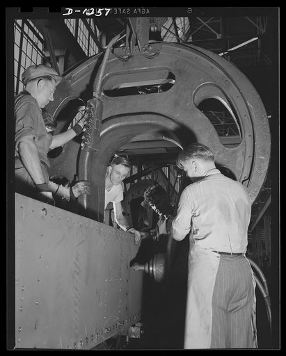 Chrysler tank arsenal. Thousands of rivets are used in the production of one of the huge thirty-eight ton M-3 tanks. Whenever possible rivets are replaced by welded sections, but throughout much of the tank, as in the side plates on which this riveter is working, the steel plate is too heavy for wel