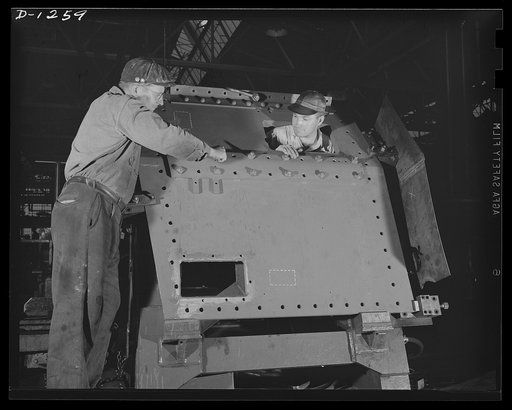 Tank manufacture (Chrysler). Thousands of rivets are used in the production of one of the huge thirty-eight ton M-3 tanks. Whenever possible rivets are replaced by welded sections, but much of the steel plate, such as the hull front plate on which these men are working, is too heavy for welding. The