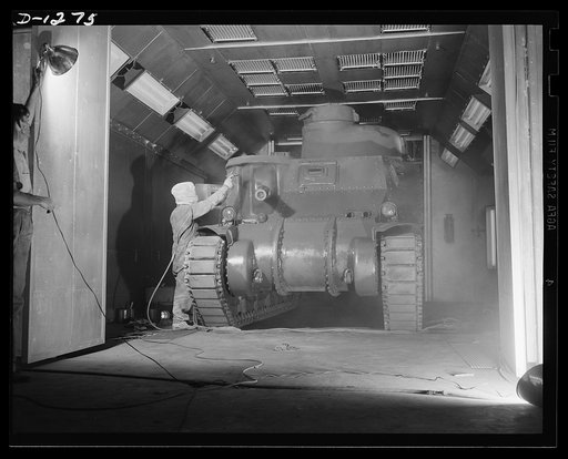 Tank manufacture (Chrysler). The final cost of olive drab paint is applied by spraygun to the twenty-eight ton M-3 tank just before it leaves the huge Chrysler tank arsenal in Detroit