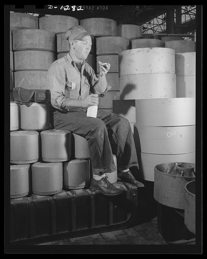 Chrysler tank arsenal. Building tanks is all right, says this worker, and he even admits it's a mighty important and necessary job, but it can't compare with stopping building tanks and going to work on pie and milk. He's eating his lunch in the midst of a pile of wheels and runners for M-3 tanks at