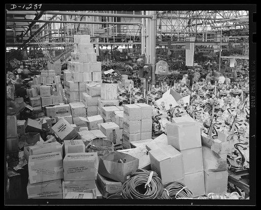 Army truck manufacture (Dodge). Piles nearly to the roof and covering a huge area of floor space is the big stock of accessories for army truck engines, such as air cleaners, oil filters, fan belts, and so forth