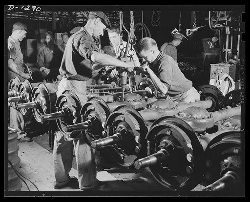 Down the production line, one after another, come the sturdy, rugged rear axles of Dodge Army trucks in the steady, smooth flowing assembly process. The axles are of the full floating type and are equipped with 14 1/8 inch brake assemblies