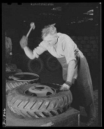Army truck manufacture (Dodge). Second operation in wheel and tire assembly, inserting the locking ring by means of which the tire is secured to the wheel