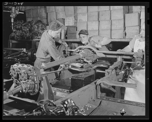 Army truck manufacture (Dodge). Detroit workmen assembling the front axle of a Dodge four wheel drive U.S. Army truck. In this operation the front driving axle is put in place and the drive shaft hooked up with the transfer case