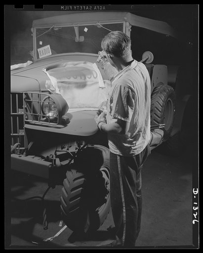 Army truck manufacture (Dodge). Special blue drab paint sprayed through the stencil affixes the government serial number of each Dodge Army truck permanently on the sides of the hood where they can be easily seen