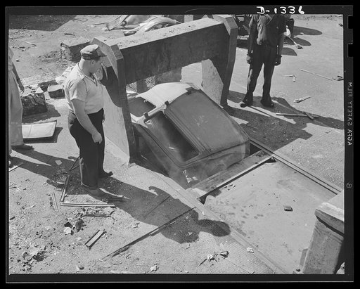 Jalopies for defense. It won't be an auto body for long now. Here it is being placed in a powerful hydraulic baling press, soon to emerge as a small cube of tightly compressed metal. The steel is bundled in this way not alone to facilitate shipment but also, and more important, to prevent the burnin