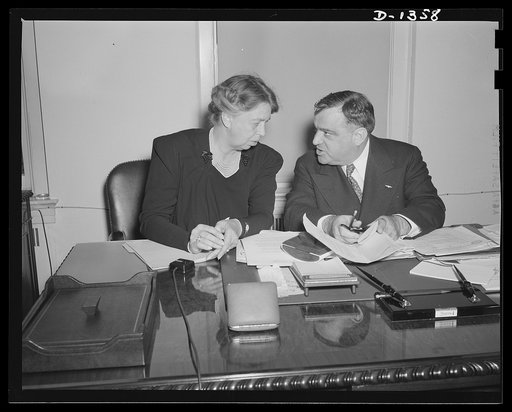 Mrs. Eleanor Roosevelt and Mayor Fiorello H. La Guardia in the latter's office in Washington on the occasion of Mrs. Roosevelt's being sworn in as Mayor La Guardia's assistant in the Office of Civilian Defense. Mrs. Roosevelt's title is Assistant Director of the Office of Civilian Defense. The cerem