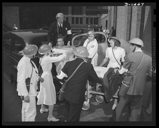 Civilian protection. Victim of a bombing raid is brought to a hospital or receiving station by a member of the drivers corps