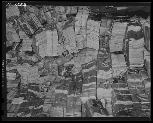 Waste paper. Outdated telephone directories are a good source of the paper packing so badly needed today for shipment of defense and lend-lease goods. This pile of directories is in the stock room of a Philadelphia paper mill, which will make pasteboard packing out of it