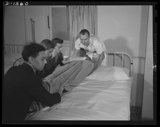 Civilian protection. Handle him carefully, boys! Victim of an air raid is brought into a hospital where volunteers trained in first aid place him carefully on a cot