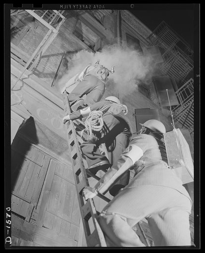 Civilian protection. Fully equipped to cope with any situation they may encounter these New York City volunteer auxiliary firemen put on a demonstration of the matter in which they would handle the damage caused by an incendiary bombing attack. An incendiary bomb has fallen through the roof of this 