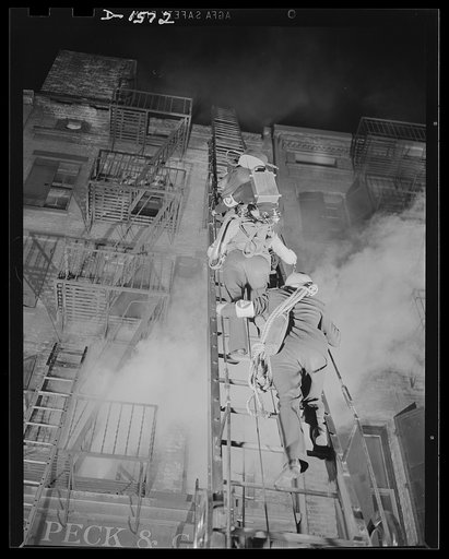 Civilian protection. Fully equipped to cope with any situation they may encounter these New York City volunteer auxiliary firemen put on a demonstration of the matter in which they would handle the damage caused by an incendiary bombing attack. An incendiary bomb has fallen through the roof of this 