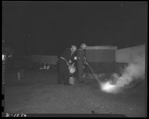 Civilian protection. This spray of water accelerates the burning of the magnesium bomb and cools the surrounding. While this picture serves as a demonstration, it is improbable that such a bomb would be found on a roof like this. Falling from a great height it would burn through and lodge in the upp