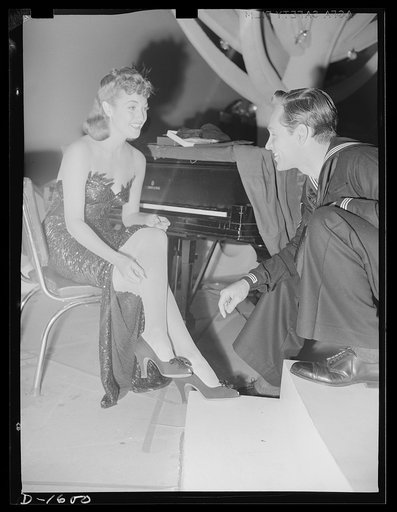 Cotton stockings. Dorothy Lamour on the set of "The Fleet's In," with her costume as a nightclub singer in the picture, she is wearing fine point lisle mesh stockings which have been specially designed for evening wear