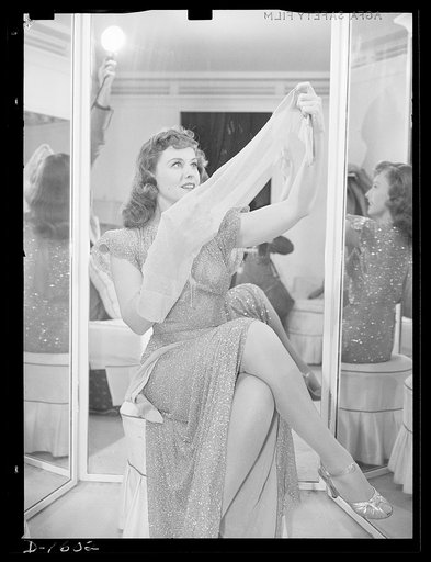 Cotton stockings. Paulette Goddard illustrates the new fashion trend of having her hose blend in color with her evening dress. The dress she wears is gold bugle beads, designed by the famous Hollywood designed, Edith Head. Her stockings are gold-colored sheer crepe lisle
