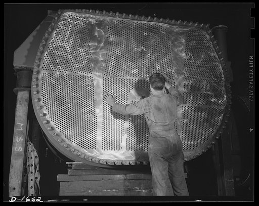 Shipbuilding (Newport News). This worker is touching up one of the huge condensers for a U. S.Navy destroyer under construction