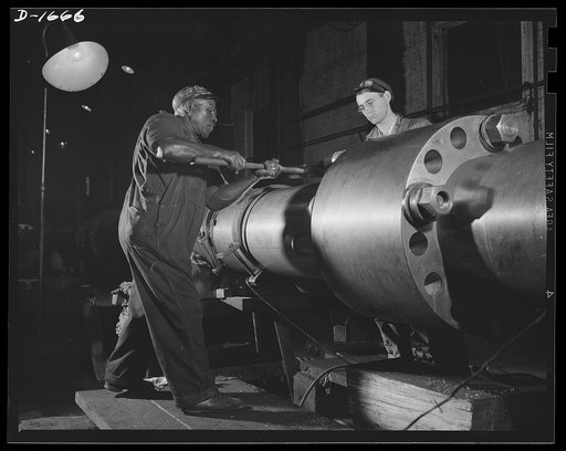 Shipbuilding (Newport News). Skilled work requires brawn as well as brains. This husky navy yard worker is driving home a pin in the propeller shaft of a naval vessel under construction