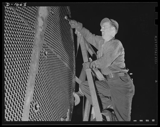 Shipbuilding (Newport News). This worker is touching up one of the huge condensers for a U.S. Navy destroyer under construction