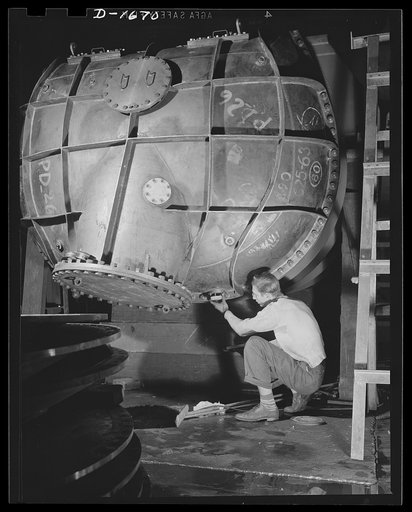 Shipbuilding (Newport News). This worker is touching up one of the huge condensers for a U.S. Navy destroyer under construction
