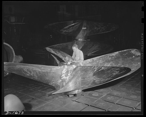 Shipbuilding (Norfolk Navy Yard). The push for the navy is supplied by huge propellers such as these. This four-bladed monster, cast in one place, is being inspected before it is installed on a warship