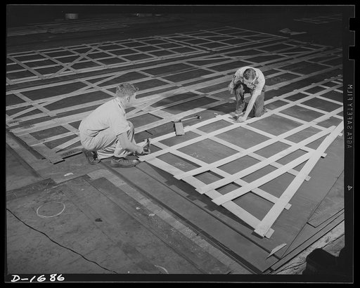 Shipbuilding (Newport News). These are mold loft workers laying out patterns for various parts of naval vessels under constructions. These patterns are subsequently transferred to steel