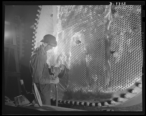 Shipbuilding (Newport News). This worker is touching up one of the huge condensers for a U.S. Navy destroyer under construction