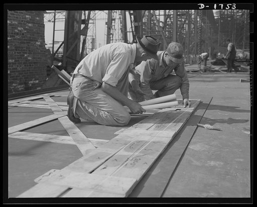 Shipbuilding (Newport News). These workers are marking off the design for a ship's plate, using a template as a guide