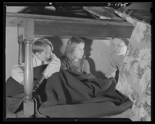 Air raid protection--what to do in your home. This is not the way to spend the evening, but simply a handy place to go if bombs suddenly start falling nearby. A heavy, sturdy table will not only keep off falling plaster that may be shaken down by a nearby burst, but would even help to support beams 