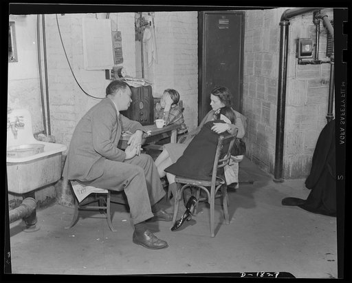 Air raid protection--what to do in your home. This is not the most comfortable place in the world for a refuge, but it has its points. In case of damage to the house, the occupants could get out either through the window at the left or the door at the right. The cellar ceiling is extra braced with i