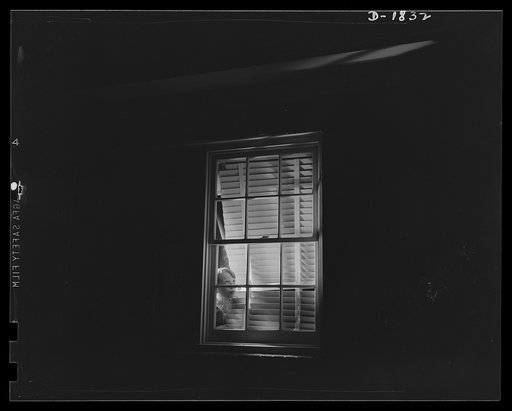 Air raid protection--what NOT to do when alarm sounds. DON'T look out the windows. Johnnie doesn't mean to be a fifth columnist, but in looking out and attempting to see the planes he's flashing a swell signal just the same; in addition this is a dangerous place for him to be because of flying glass
