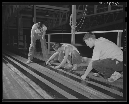 Barrage balloon manufacture. Making a suspension band. These workers are preparing a reinforced band which will be attached longitudinally around the barrage balloon. This band carries most of the rigging by which the balloon is controlled from the ground. General Tire and Rubber Company, Akron, Ohi