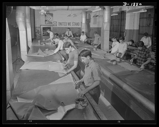 Barrage balloon manufacture. Lineup of cementers. Assembling patterns into gores which in turn are assembled into balloon sections, these workers are charged with making seams strong and gas-tight, since the full tug of gas from the inside, and rigging on the outside is exerted on these sections. Ge