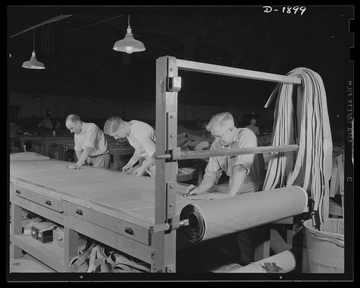 Assault boat Production. Building assault boats for U.S. Marine Corps. Early step in preparation for manufacture of boats: layout of various patterns on fabric of which the boats are made illustrated in this picture. Goodyear, Akron, Ohio