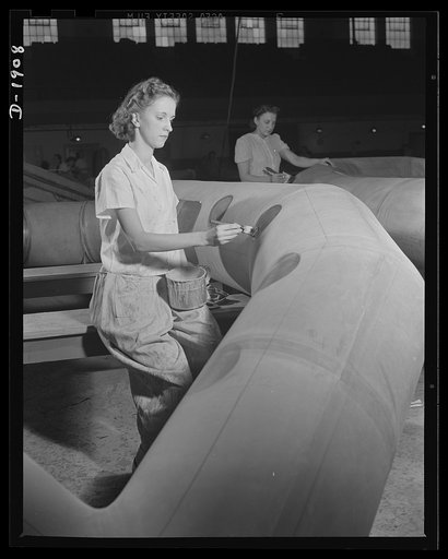 Assault boat Production. Building assault boats for U.S. Marine Corps. Coat of rubber cement is applied wherever fixtures are to be attached and method of applying them is quite similar to applying a repair patch to an automobile inner tube. Goodyear, Akron, Ohio
