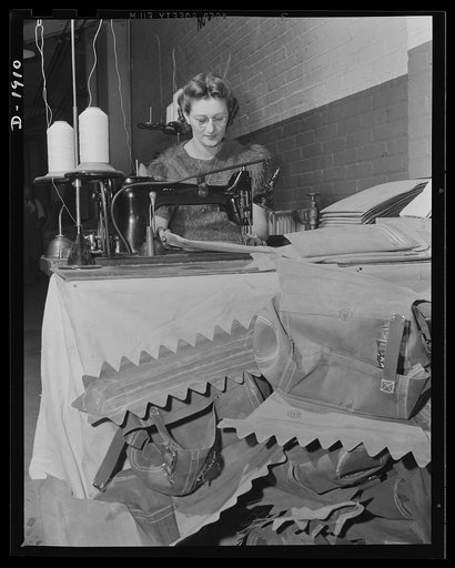 Assault boat Production. Building assault boats for U.S. Marine Corps. The art of the seamstress has a place in the building of these boats, as illustrated here. Worker is stitching various accessories which will be applied to boats in the course of their construction. Goodyear, Akron, Ohio
