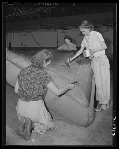 Assault boat Production. Building assault boats for U.S. Marine Corps. Women workers apply preservative waterproof paint to bottom of boat which is nearing completion. Goodyear, Akron, Ohio
