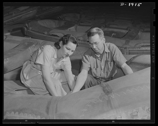 Assault boat Production. Building assault boats for U.S. Marine Corps. Supervisor instructs employee in the balloon room in one of the production steps in boat manufacture. Goodyear, Akron, Ohio