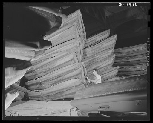 Assault boat Production. Building assault boats for U.S. Marine Corps. Stacks of boats ready for deflation and packing are shown in the balloon room. Goodyear, Akron, Ohio