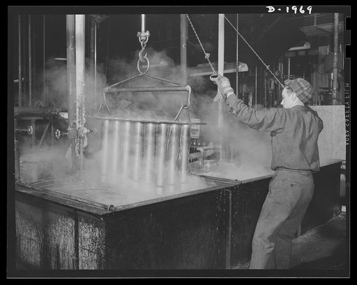 Three-inch A.A. cartridge cases. Between the drawing operations which process an antiaircraft cartridge case from a flat metal disc, the partly-finished cases are washed and annealed. When they move on to the next drawing operation, the surfaces are free of scale and other adhesions and the metal is