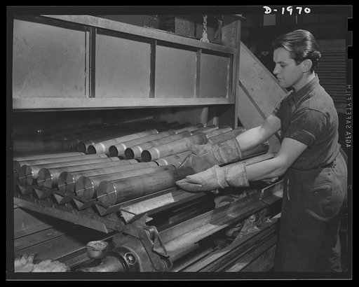Three-inch A.A. cartridge cases. Antiaircraft cartridge cases are unloaded from a stress-annealing furnace which has made them soft, uniform and ductile, ready for succeeding machine operations. The big Midwest plant doing this work is ideally equipped for volume production of war necessities like t
