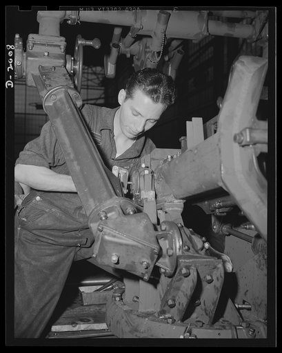 Antiaircraft gun carriage. Assembling the foot firing mechanism on a thirty-seven-millimeter antiaircraft gun carriage. The gunner requires both hands to follow his swiftly moving target, and must get in as many shots as he can while the target is still within range. War program production scene in 