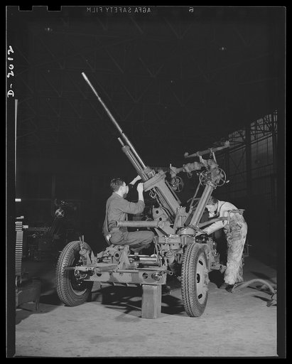 Antiaircraft gun carriage workers. Workers assembling the elevating mechanism of one of America's many new thirty-seven-millimeter antiaircraft gun carriages. These guns will soon take their place in the protection of our soil against the best-armoured and the fastest-flying planes that our enemies 