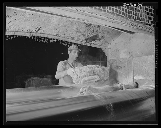 On the mill rollers. First the raw rubber is wedged into the revolving steel drums and mashed into a flat sheet which clings to one of the rollers like clothes sometimes stick to a clothes-wringer. Powders and liquids tossed into the center of this surging mass soon become a part of it. Firestone (G