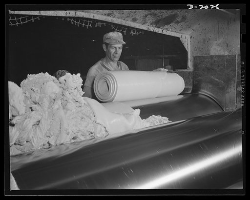 As the steel rollers revolve, the worker slashes out a section of a size easy to handle and rolls it into an armful. He holds his razor tightly against the drum until the proper amount has rolled up, then makes a quick, diagonal slash across the drum, cutting this piece away from the milling roll, a