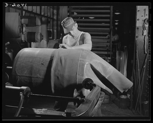Tire building. This tire builder starts the carcass by slipping a layer of fabric onto the tire drum. The layer is made with the seam cut on the bias so that there will be no straight-across strain on the tire seams.  The layer fits tightly, and each successive layer is banded to the preceding one b