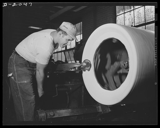 Forming the bead with "saucer," this tire builder follows every curve of the tire, shaping and pressing on the new layer. This saucer is matched by another on the far side of the tire which works on the other side at the same time, assuring perfect balance of the finished tire. The saucers may be sw