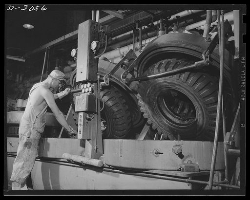 Molds automatically open. At the end of the curing time, the mold draws the steam out of the airbag, opens the lid and ejects the tire from the tread pattern. Workers need to do nothing but pull out the finished tire and put in another uncured carcass. General Tires, Firestone, Akron, Ohio