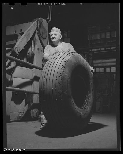 Rolling for Uncle Sam. Rolling away a finished tire, this tire company worker is proud of the job it will do, for it is a huge airplane bomber tire, of the kind used by Uncle Sam on his giant defenders. The tire will receive a few finishing touches before shipping, although it is ready for service a